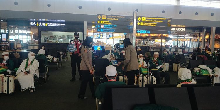 Polwan Bagi-bagikan Masker ke Jamaah Umrah di Bandara Soetta